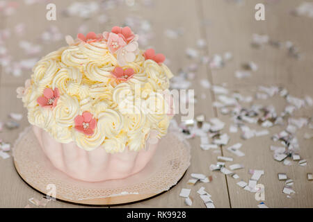 Primo compleanno di torta rosa con fiori per la piccola bambina e decorazioni per torta smash. Foto Stock