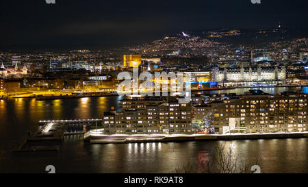 Porto di Oslo con nuove case di famiglia di notte. La foto è stata scattata dalla collina Ekeberg. Foto Stock