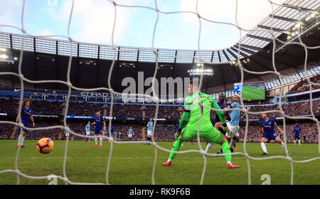 Manchester City Sergio Aguero (centro destra) batte Chelsea goalkeeper Kepa Arrizabalaga al cliente il suo lato il terzo obiettivo del gioco durante il match di Premier League al Etihad Stadium e Manchester. Foto Stock