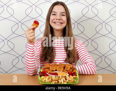 Felice ragazza adolescente con gustosi pepite di pollo fast food Foto Stock