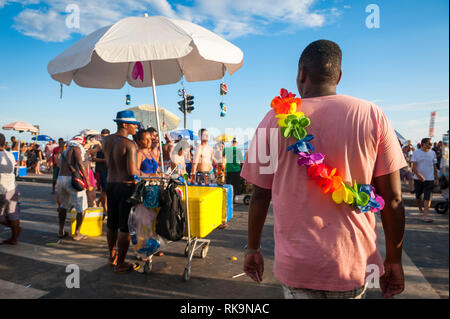 RIO DE JANEIRO - 28 febbraio 2017: Unlicensed fornitori brasiliani che serve bevande e snack la linea la strada per i clienti ad una festa di carnevale. Foto Stock