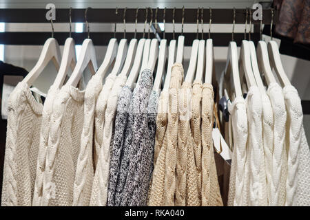 Elegante maglioni multicolore su rack Foto Stock