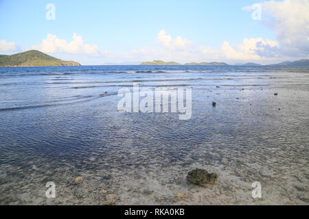 La bassa marea al tramonto su una spiaggia di San Tommaso Isola, noi VI. La laminazione delle onde del mare e le isole lontane all'orizzonte. Foto Stock