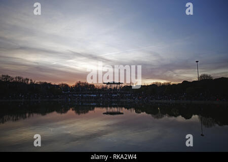 Madrid, Madrid, Spagna. Il 9 febbraio, 2019. Vista del tramonto sul Lago Prodolongo momenti prima della inaugurazione del nuovo anno festival.persone raccolte presso il lago Prodolongo a testimoniare l inaugurazione del nuovo anno cinese con fuochi d'artificio, in tempi antichi erano tradizionalmente accesa per spaventare il mostro Nian, metà drago, metà lion, che secondo la leggenda ha attaccato gli abitanti del villaggio e a volte divorato i bambini, ma potrebbe essere cacciati con forti rumori. In aggiunta, essi distanziati gli spiriti maligni, che altrimenti potrebbero portare sfortuna. (Credito Immagine: © Mario Roldan/SOPA immagini via Foto Stock