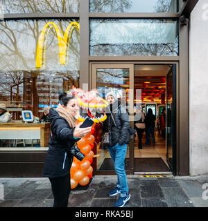 London, Regno Unito - Feb 10, 2019: turisti pongono di fronte a un drago al ristorante McDonald's durante il Nuovo Anno Cinese a Londra, Regno Unito. Varie prestazioni tradizionali attirano migliaia di persone per strada Credito: Alexandre Rotenberg/Alamy Live News Foto Stock
