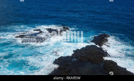 Spruzzi delle onde sulle rocce nell'oceano Foto Stock