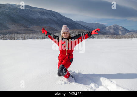 Giovane ragazza sta avendo divertimento di inverno su una giornata nevosa e soleggiata a Lika, Croazia Foto Stock