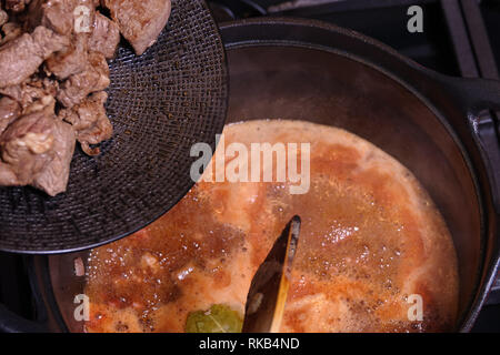 Gulasch di manzo o di cottura Stufato. La carne bovina è in procinto di essere gettato nella padella. Foto Stock