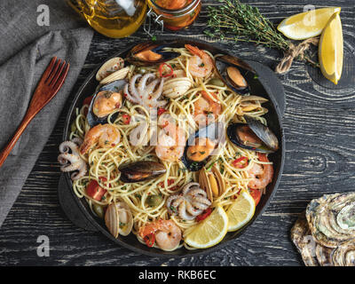 La pasta cotta con vongole, gamberetti, polipetti, cozze pomodoro su una padella , spaghetti. Close up Foto Stock