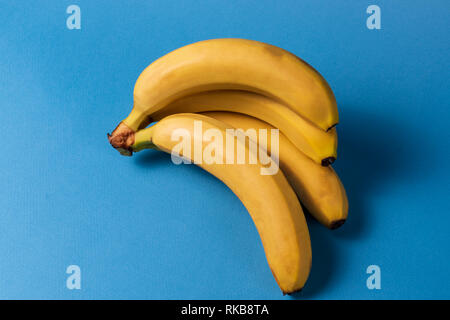 Il minimalismo creativi concetto. Concetto di imprevisti. Appartamento vista laici di banana frutto pattern colorati su sfondo blu. Foto Stock