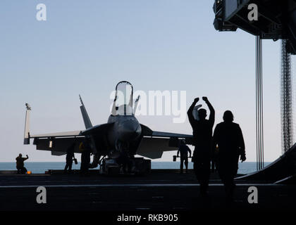 Stati Uniti I marinai dirigere un'F/A-18E Super Hornet, assegnato a Strike Fighter Squadron (VFA) 97, su un aeromobile ascensore nell'hangar bay a bordo della portaerei USS John C. Stennis CVN (74) nell'Oceano Pacifico, Febbraio 9, 2019. John C. Stennis è distribuito negli Stati Uniti 7 flotta area di operazioni a sostegno della sicurezza e della stabilità nella regione Indo-Pacifico. (U.S. Foto di Marina di Massa Specialista comunicazione marinaio Jarrod A. Schad) Foto Stock