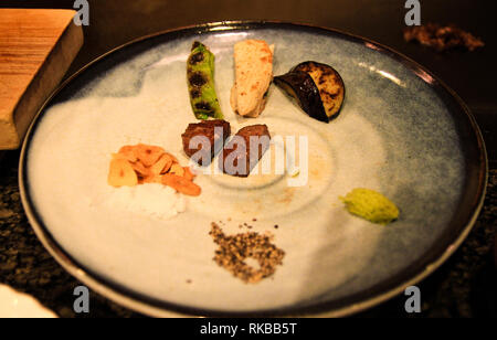 Piastra di grigliate di manzo di Kobe aglio, pepe nero, wasabi e verdure a un originale ristorante Yakiniku a Kobe, Giappone Foto Stock