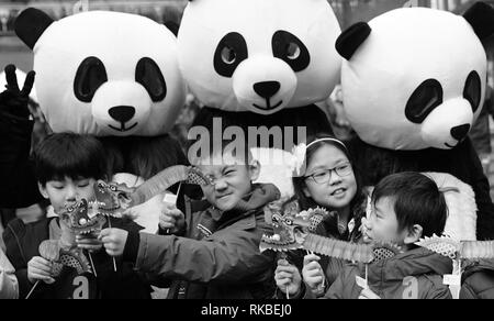 Anno Nuovo Cinese in Chinatown a Londra con il panda in bianco e nero e i bambini cinesi fotografato in prima linea. Foto Stock