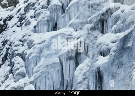 Congelati, ghiaccio freddo dettaglio cascata, contrastato il gocciolamento ghiaccioli, linee. Texture di sfondo d'inverno. Foto Stock