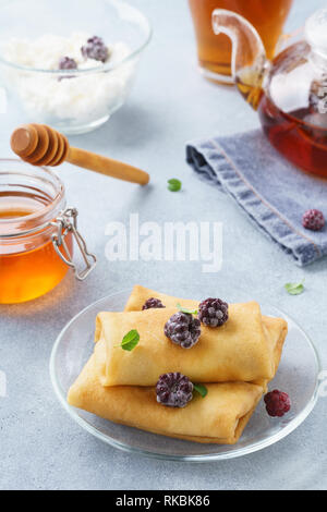 Ricotta blintzes. Crepes ripiene con miele e more. Foto Stock