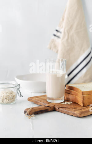 Il brunch o tavolo per la colazione. Latte di avena con crostini di pane su un tavolo di legno. Colazione sana nozione Foto Stock