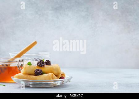 Ricotta blintzes. Crepes ripiene con miele e more. Foto Stock