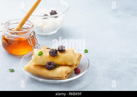 Ricotta blintzes. Crepes ripiene con miele e more. Foto Stock