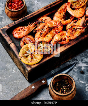 Gamberoni arrosto sul tagliere di legno.pesce alla griglia Foto Stock