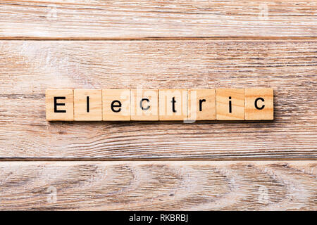 Electric parola scritta sul blocco di legno. Testo elettrico sul tavolo in legno per il desing, concetto. Foto Stock