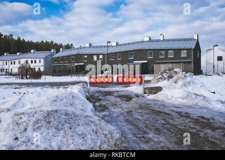 Coperte di ghiaccio strada conduce alla barriera e comunità di case, Upplands Vasby, Stoccolma, Svezia e Scandinavia Foto Stock