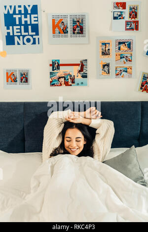Trasmissione via IR di felice imprenditrice sentirsi felice giacente nel suo letto Foto Stock