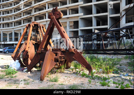 Rusty gru grabber di fronte hotel abbandonato in Montenegro. Foto Stock
