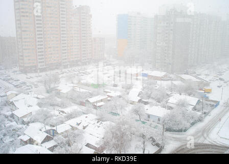 Nevicate invernali in zona residenziale con contrasto di urbano moderno appartamento edifici e la vecchia casa privata, Kiev, Ucraina Foto Stock