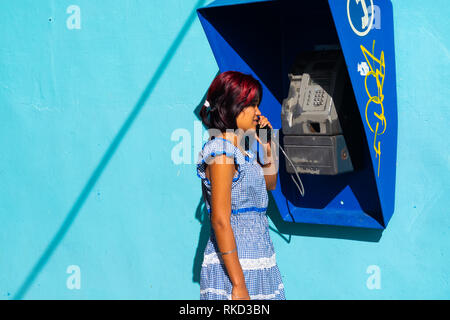 Donna che utilizza telefono pubblico a l'Avana, Cuba Foto Stock