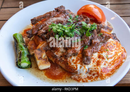 Bagno turco manisa kebap servita su pane pita coperti con la salsa e yogurt. Foto Stock