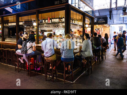 Barcellona, Spagna - CIRCA NEL MAGGIO 2018: Persone in La Boqueria gustando tapas spagnole. Questo è un grande mercato pubblico nella Ciudad Vieja distretto di Barcelo Foto Stock