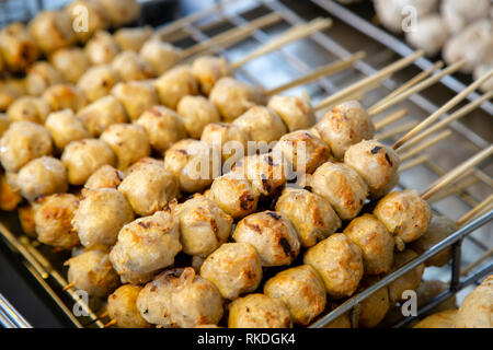 Una disposizione di spiedini di grigliate di guardare Chin Ping o Thai carne di maiale alla griglia polpette di carne. Guardare il mento è un popolare Thai street food snack e stuzzichini in Thail Foto Stock