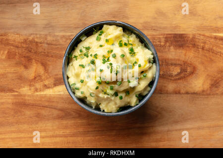 Pomme purea, una foto aerea di una tazza di purea di patate con erbe aromatiche, girato dalla parte superiore su un sfondo rustico con un posto per il testo Foto Stock