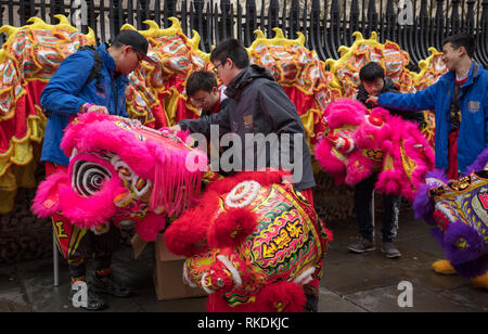 Bambini e genitori preparando la lunga dragon per camminare nel nuovo anno cinese Parade, Londra, Regno Unito. Foto Stock