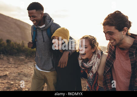 Gruppo di amici social network sul viaggio escursionistico. Giovani uomini e donne escursionismo insieme sul sentiero di montagna. Foto Stock