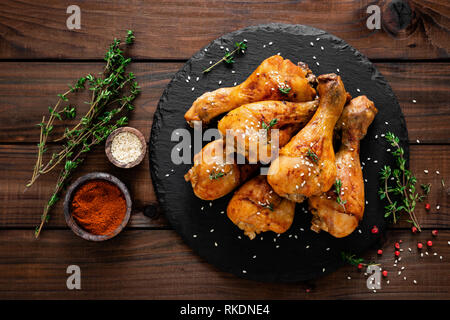 Pollo alla griglia gambe su sfondo di legno. Vista superiore Foto Stock