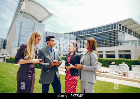 Imprenditore in un estate città con tre donne Foto Stock