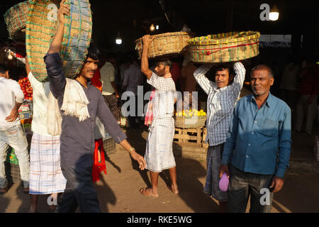 Facchini con i loro cestini a Crawford Mercato del Mahatma Jyotirao Phuke mercato, un commercio all'ingrosso di frutta e verdura in Mumbai, India Foto Stock