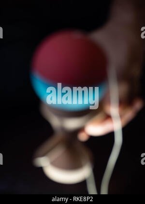 Sfocata abstract classico gioco giapponese kendama su sfondo nero. Foto Stock