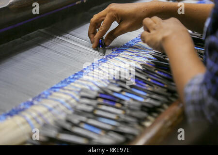 La tessitura della seta e della tessitura le mani, Myanmar Foto Stock