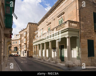 Edificio esterno a St Julians Malta tipici balconi a sbalzo e balaustra con colonne Foto Stock