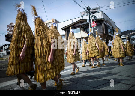 Kaminoyama, Giappone. Xi Febbraio, 2019. I partecipanti vestiti in 'Kendai' o un uccello sagomato cappotti di paglia passeggiate al villaggio per eseguire una danza durante il "Festival Kasedori' in Kaminoyama, prefettura di Yamagata, Giappone, nel febbraio 11, 2019, a pregare per il buon raccolto, buona fortuna e la prevenzione degli incendi mentre la popolazione locale attendere per le strade con benne e mestoli di spruzzi di acqua fredda su esecutori. (Foto di Richard Atrero de Guzman/Aflo) Credito: Aflo Co. Ltd./Alamy Live News Foto Stock