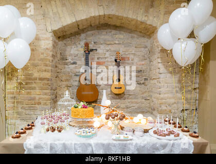 Camera di compleanno con palloncini, chitarre e tabella di dolci, torte, dolciumi Foto Stock
