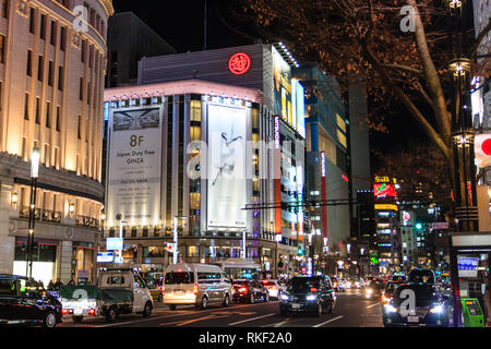 Tokyo Ginza, notte. Vista lungo la strada, Mitsukoshi department store con il gigante affissioni, "dazio libero', nella parte anteriore del 4-chome crocevia del traffico pesante. Foto Stock