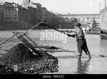 Lavoratore in una buca di sabbia, il fiume Arno, Ponte Vecchio, Firenze, Toscana, Italia 1920 1930 Foto Stock