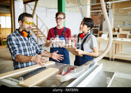 Falegname specializzato lavora con stagisti Foto Stock