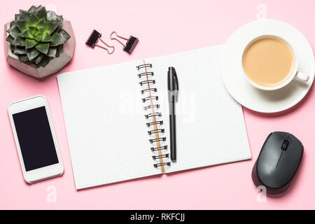 Office Workplace con notepad, tazza di caffè e la tastiera sulla scrivania di colore rosa. Foto Stock