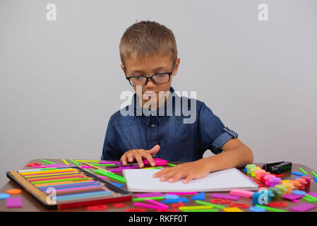 Il ragazzo è impegnato nella creatività presso la tabella richiama. Le classi di Creative si torna a scuola Foto Stock