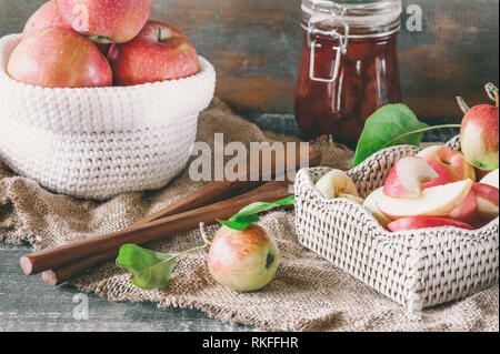 Il raccolto di mele rosse in un cestello, per la produzione di marmellate e conserve sul tavolo. In casa di sbozzati Foto Stock