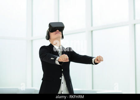Felice giovane imprenditore nel casco di realtà virtuale e ciò Foto Stock
